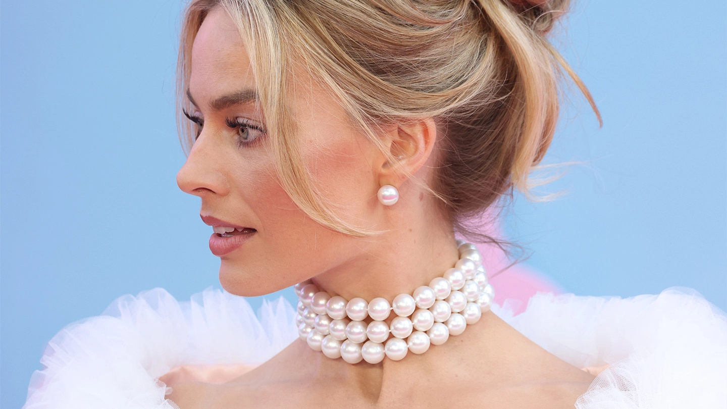 Margot Robbie wearing a triple strand white South Sea pearl necklace and stud earrings Margot Robbie wearing a triple strand white South Sea pearl necklace and stud earrings