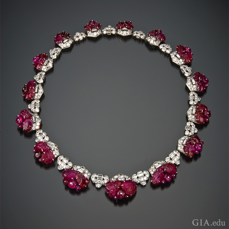 1930’s art deco carved ruby and diamond necklace shows off the July birthstone. Ruby beads are secured to the frame by white metal posts capped with a tiny diamond.