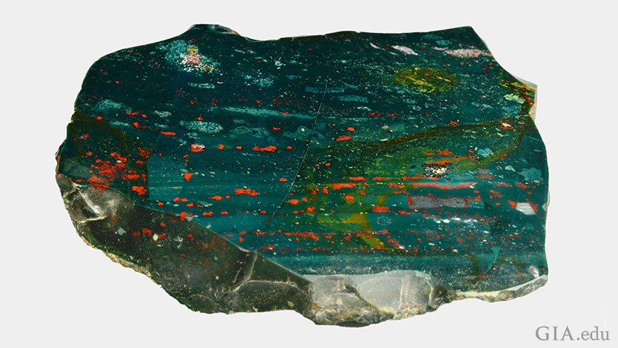 A giant slab of the March birthstone, bloodstone, is green with red, yellow, and white spots.