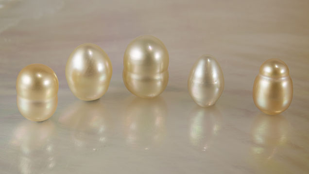 Figure 1. Five cream to orangy yellow South Sea cultured pearls (Pinctada maxima), ranging from 0.96 × 0.64 mm to 1.03 × 0.83 mm. Photo by Nuttapol Kitdee.