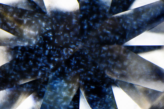 Photomicrograph of a 0.62 carat diamond showing a delicate, interlinked cross-shaped cloud inclusion pattern—an unusual structure not previously observed in GIA laboratories; field of view 2.40 mm.