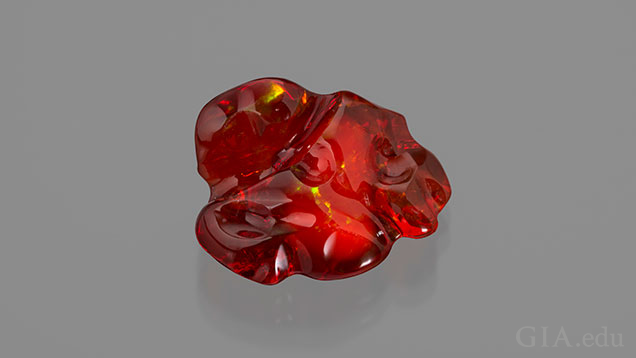 A free-form piece of orangey-red fire opal. A free-form piece of orangey-red fire opal.