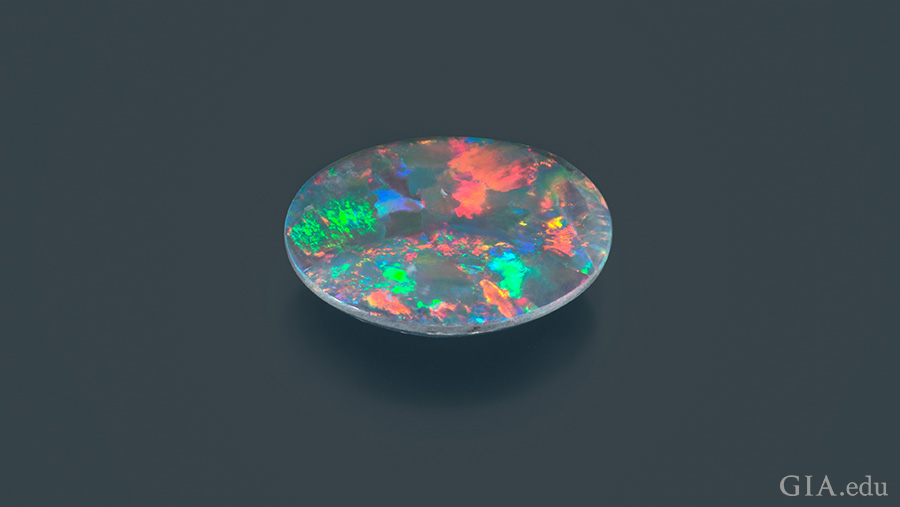 Specks of pink, green, blue, and orange are found on the colorful 1.72 carat October birthstone, opal. Specks of pink, green, blue, and orange are found on the colorful 1.72 carat October birthstone, opal.