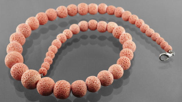 Figure 1. This string of orangy pink “soft coral” beads (6–15 mm in diameter) displayed a rough surface and large pores. Photo by Gagan Choudhary.