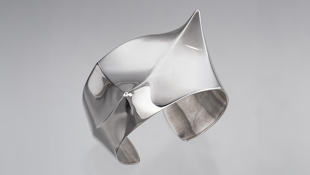 Figure 2. One of two identical silver hollow-form bracelets by Frank Patania Jr. This cuff, known as both “Asymmetry” and “Twin Peaks,” was made around 1960 from six pieces of sterling silver using a small superstructure for support during the soldering process. The cuff weighs 100 g and measures 7 cm (2.75 in.) at its widest point. Photo by Robert Weldon; courtesy of Patania Jewelry.