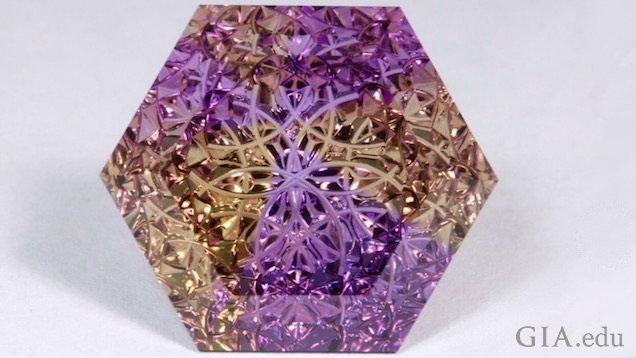 Lattice-patterned gems encase an 18K gold kaleidoscope. 