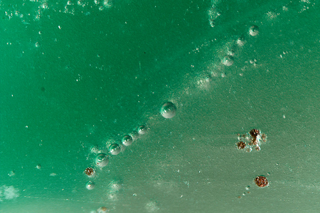 Gas bubbles of various sizes were observed in the purplish gray and green bangle.
