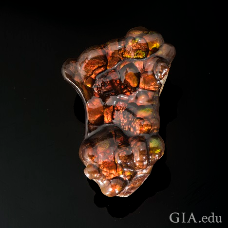 An irregular-shaped stone with orange, brown and green coloring.