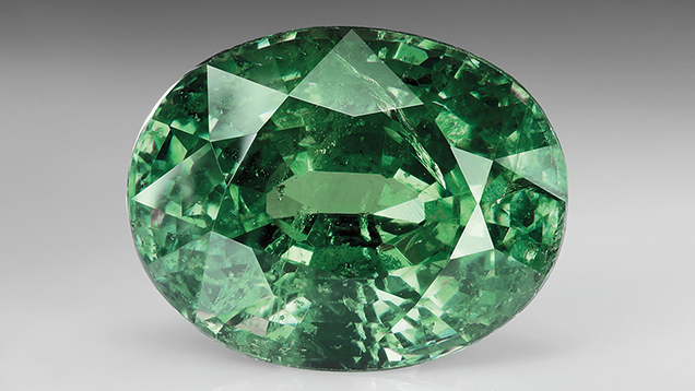 Up-close view of a faceted green gem.