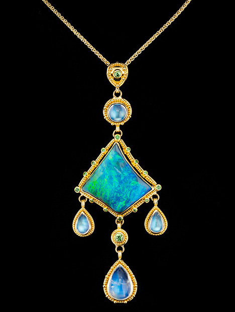 Figure 2. “Where the Ocean Meets the Sky” is a one-of-a-kind pendant featuring a 19.51 ct Australian boulder opal and 11.37 carats of blue moonstone. The boulder opal is accented with 0.63 carats of tsavorite garnet. The granulated yellow gold is 22K, and the gold links between the elements are 18K yellow gold. Photo by Robert Weldon; courtesy of Zaffiro.