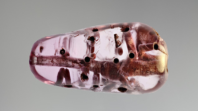 Pink sapphire bead with drill holes.