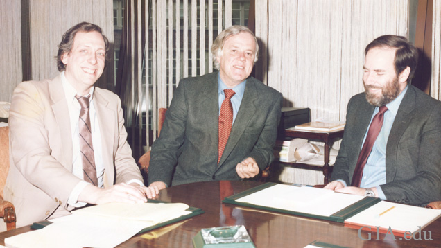 Three men at a conference table.