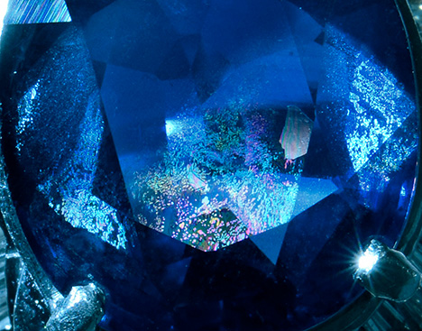 A blue sapphire features large iridescent healed fissures.