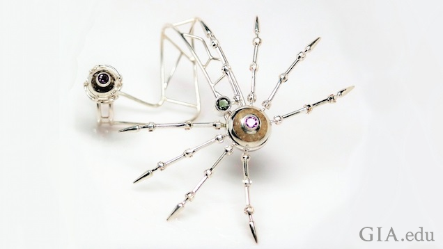 The body and legs of the spider palm bracelet rests on top of the hand; the egg and web nest are the ring.