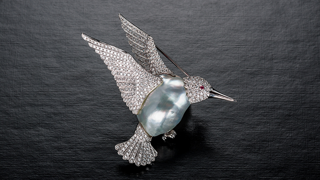 Hummingbird brooch with a baroque pearl surrounded by diamonds.