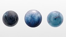 Figure 1. Three quartz spheres weighing 4.85, 5.50, and 5.40 ct, respectively, colored by blue needle-like inclusions. Photo by Rong Liang.