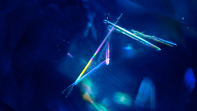 Prismatic elongated zircon in Kashmir sapphire. Photomicrograph by Narint Jaisanit; field of view 2.88 mm.