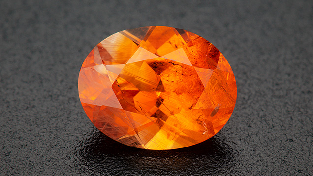 Figure 2. A 0.89 ct heated orange oval brilliant sapphire. Photo by Robert Weldon; courtesy of Greenland Ruby. Figure 2. A 0.89 ct heated orange oval brilliant sapphire. Photo by Robert Weldon; courtesy of Greenland Ruby.