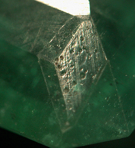 The corner patch on the emerald can be seen under magnification.