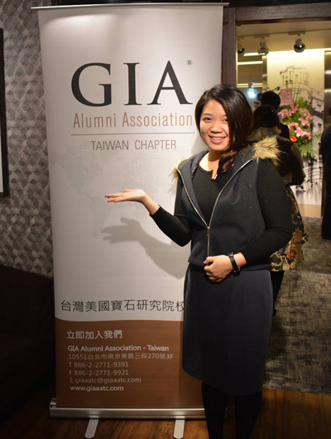イベントでGIAの垂れ幕の前に立つ女性。