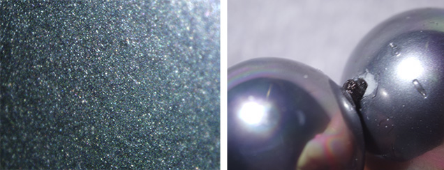 Shell pearls show glittery coating, damage near drill hole Shell pearls show glittery coating, damage near drill hole