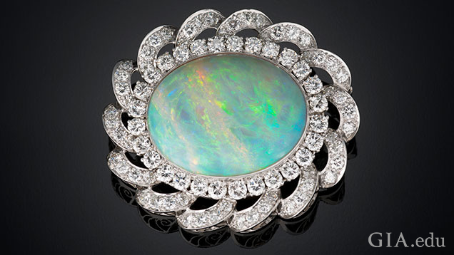 An oval shaped 33.40 ct white Australian opal and diamond pendant/brooch set in platinum. An oval shaped 33.40 ct white Australian opal and diamond pendant/brooch set in platinum.