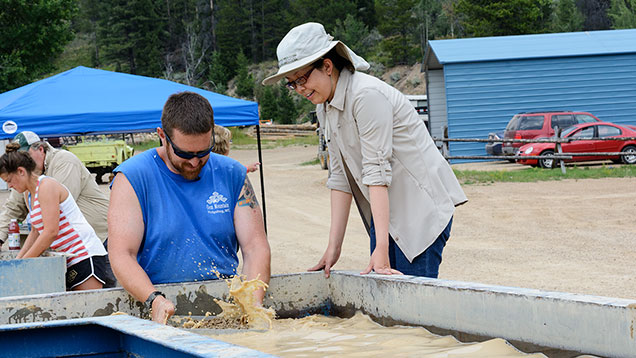 Man teaching woman how to wash sapphire gravel