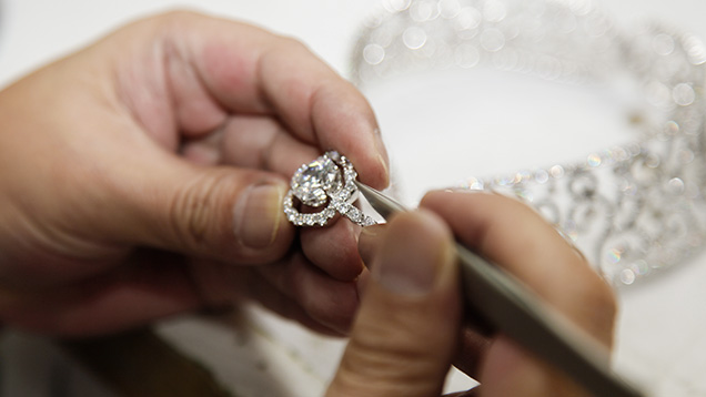 worker making final adjustments on a high-end diamond jewelry suite worker making final adjustments on a high-end diamond jewelry suite
