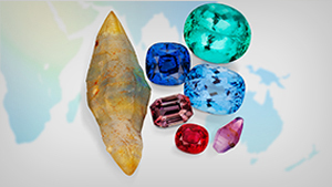 An array of rough and polished colored gemstones sitting on a world map. An array of rough and polished colored gemstones sitting on a world map.