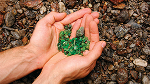 Hands holding rough tsavorite in the field Hands holding rough tsavorite in the field