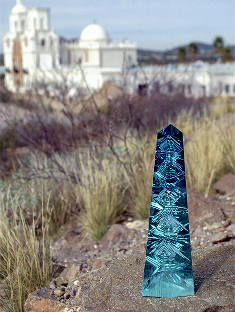 前景为立在岩石上的 Dom Pedro（多姆·佩德罗）海蓝宝石，背景为一座教堂。