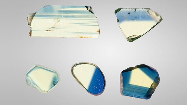 Figure 3. A selection of bicolor wafers. The weak color saturation in the yellow areas of some samples results from fabricating them thin enough that both yellow and blue areas were well within the dynamic range of the UV-Vis-NIR spectrophotometers. Photo by John L. Emmett. Figure 3. A selection of bicolor wafers. The weak color saturation in the yellow areas of some samples results from fabricating them thin enough that both yellow and blue areas were well within the dynamic range of the UV-Vis-NIR spectrophotometers. Photo by John L. Emmett.