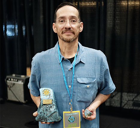 Figure 2. Mark Baca (American Turquoise Online) holds his winning piece (right) and trophy for Best in Show. Photo courtesy of the Turquoise Museum. Figure 2. Mark Baca (American Turquoise Online) holds his winning piece (right) and trophy for Best in Show. Photo courtesy of the Turquoise Museum.