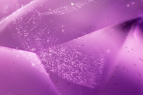 Figure 11. A veil of secondary fluid inclusions along a rehealed fracture. Note the small black hematite spherulites. Photomicrograph by Philippe Belley; field of view 3.7 mm. Figure 11. A veil of secondary fluid inclusions along a rehealed fracture. Note the small black hematite spherulites. Photomicrograph by Philippe Belley; field of view 3.7 mm.