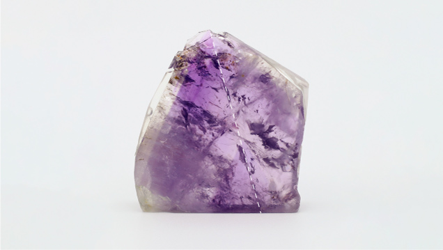 Figure 6. A 32 × 7 mm polished section of amethyst from La Manche showing oscillatory zoning and weak sector zoning. The c-axis is indicated by the dashed line. Photo by Philippe Belley. Figure 6. A 32 × 7 mm polished section of amethyst from La Manche showing oscillatory zoning and weak sector zoning. The c-axis is indicated by the dashed line. Photo by Philippe Belley.