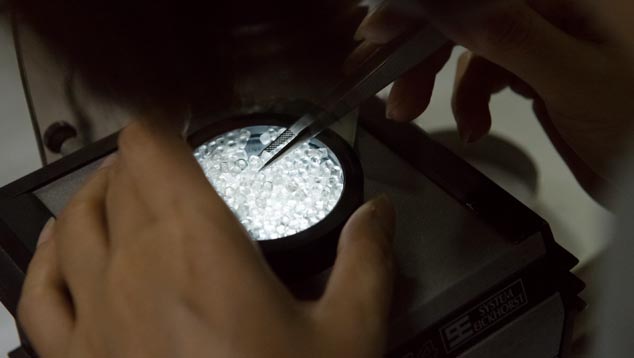 In a simple instrument called a polariscope, these diamonds are being checked for strain that could cause breakage. In a simple instrument called a polariscope, these diamonds are being checked for strain that could cause breakage.