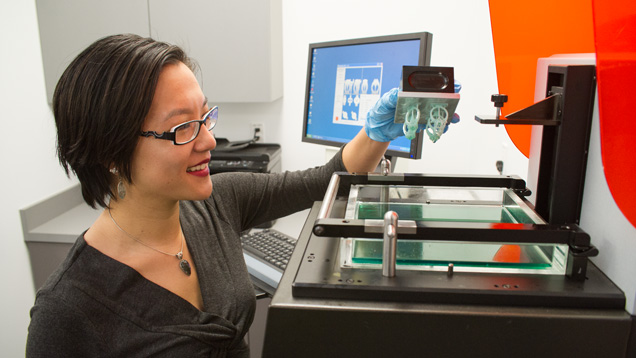 Michelle Loon removes the build platform from the 3-D printer. Photo by Kevin Schumacher Michelle Loon removes the build platform from the 3-D printer. Photo by Kevin Schumacher