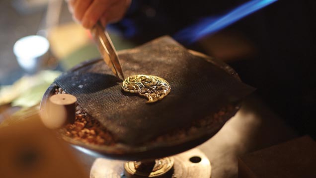 In her studio, Master Bai works on a piece of fine filigree art. Photo courtesy of Zhao Yi Xin Tiandi Co., Ltd.