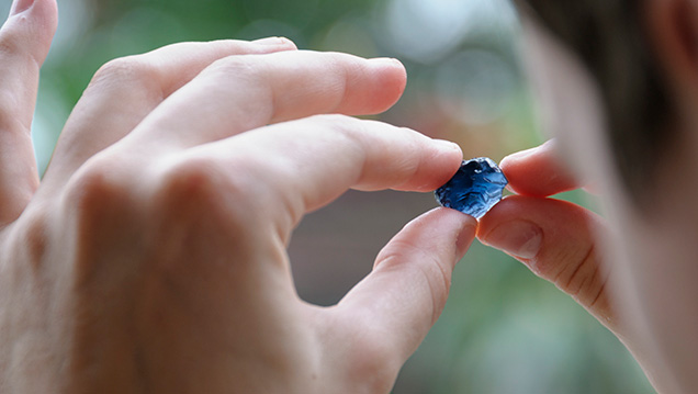 Examining a blue spinel crystal Examining a blue spinel crystal