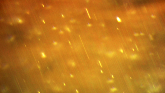 Photomicrograph of extremely fine needle-like particles in chrysoberyl Photomicrograph of extremely fine needle-like particles in chrysoberyl