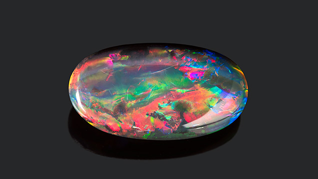 Black opal cabochon from Lightning Ridge. Black opal cabochon from Lightning Ridge.