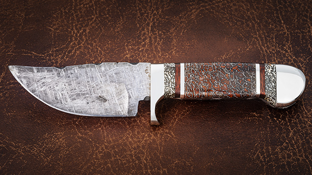 Knife with meteorite blade and gem dinosaur bone handle.