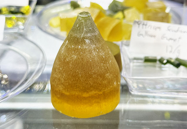 Figure 2. The top of a YAG boule doped with cerium and neodymium and produced by the Czochralski method, measuring approximately 36 mm in diameter and 45 mm tall. Parts of the boule that cannot be used for scientific purposes can be sold to the gem and jewelry trade for faceting. Photo by Lisa Kennedy; courtesy of Turtle’s Hoard.