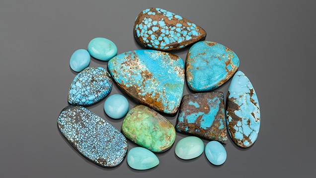 alt="A collection of various turquoise stones in different shapes and sizes, featuring vibrant blue and green hues with brown matrix patterns."