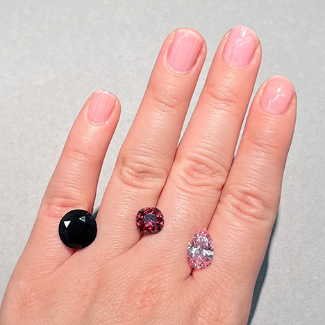 Figure 3. The Winston Red diamond (center, 2.33 ct), alongside the much darker “red-brown” DeYoung Red (left, 5.03 ct) and the DeYoung Pink diamonds (right, 2.82 ct). All three stones are currently on public exhibit at the Smithsonian NMNH. Photo by Gabriela Farfan. Figure 3. The Winston Red diamond (center, 2.33 ct), alongside the much darker “red-brown” DeYoung Red (left, 5.03 ct) and the DeYoung Pink diamonds (right, 2.82 ct). All three stones are currently on public exhibit at the Smithsonian NMNH. Photo by Gabriela Farfan.