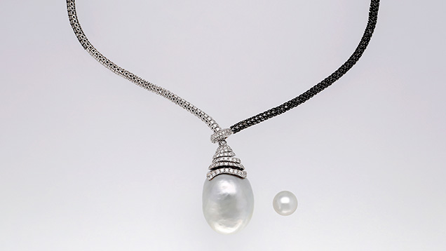 Figure 1. A South Sea bead cultured pearl measuring approximately 31.00 × 28.07 × 27.24 mm set in a lariat necklace, shown alongside a typical 12 mm South Sea cultured pearl (right). Photo by Sood Oil (Judy) Chia. Figure 1. A South Sea bead cultured pearl measuring approximately 31.00 × 28.07 × 27.24 mm set in a lariat necklace, shown alongside a typical 12 mm South Sea cultured pearl (right). Photo by Sood Oil (Judy) Chia.
