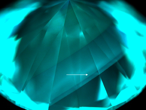 Figure 3. DiamondView imaging of the pavilion of the 1.09 ct diamond. The fluorescence color was consistent with HPHT-treated CVD-grown diamond. The region corresponding to the blue band is indicated by an arrow. Figure 3. DiamondView imaging of the pavilion of the 1.09 ct diamond. The fluorescence color was consistent with HPHT-treated CVD-grown diamond. The region corresponding to the blue band is indicated by an arrow.