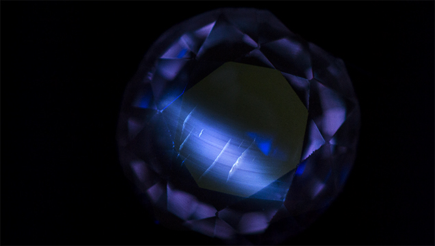 Flame-fusion synthetic sapphire displays curved banding under short-wave UV light. Flame-fusion synthetic sapphire displays curved banding under short-wave UV light.