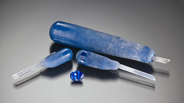 Figure 4. Flame-fusion synthetic sapphire boules and an oval-cut gem (2.45 ct). Photo by Robert Weldon. Cut stone gift of Aaland Gem Co. Inc., GIA Museum no. 24224. Figure 4. Flame-fusion synthetic sapphire boules and an oval-cut gem (2.45 ct). Photo by Robert Weldon. Cut stone gift of Aaland Gem Co. Inc., GIA Museum no. 24224.