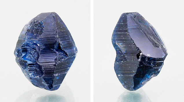 Figure 1. This unusually large 64.70 ct rough specimen displaying a bipyramidal crystal habit and stepped striations was identified as a flux-grown synthetic sapphire. Note the large rhombohedral face in the image on right. Photos by Gagan Choudhary. Figure 1. This unusually large 64.70 ct rough specimen displaying a bipyramidal crystal habit and stepped striations was identified as a flux-grown synthetic sapphire. Note the large rhombohedral face in the image on right. Photos by Gagan Choudhary.